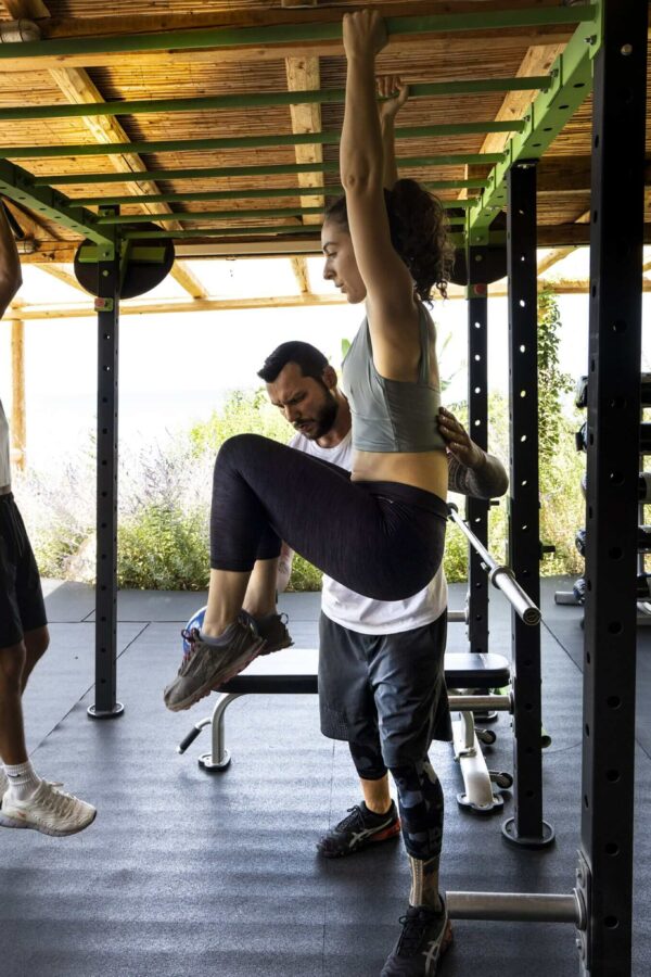 a woman and a man exercising on an outdoor gym