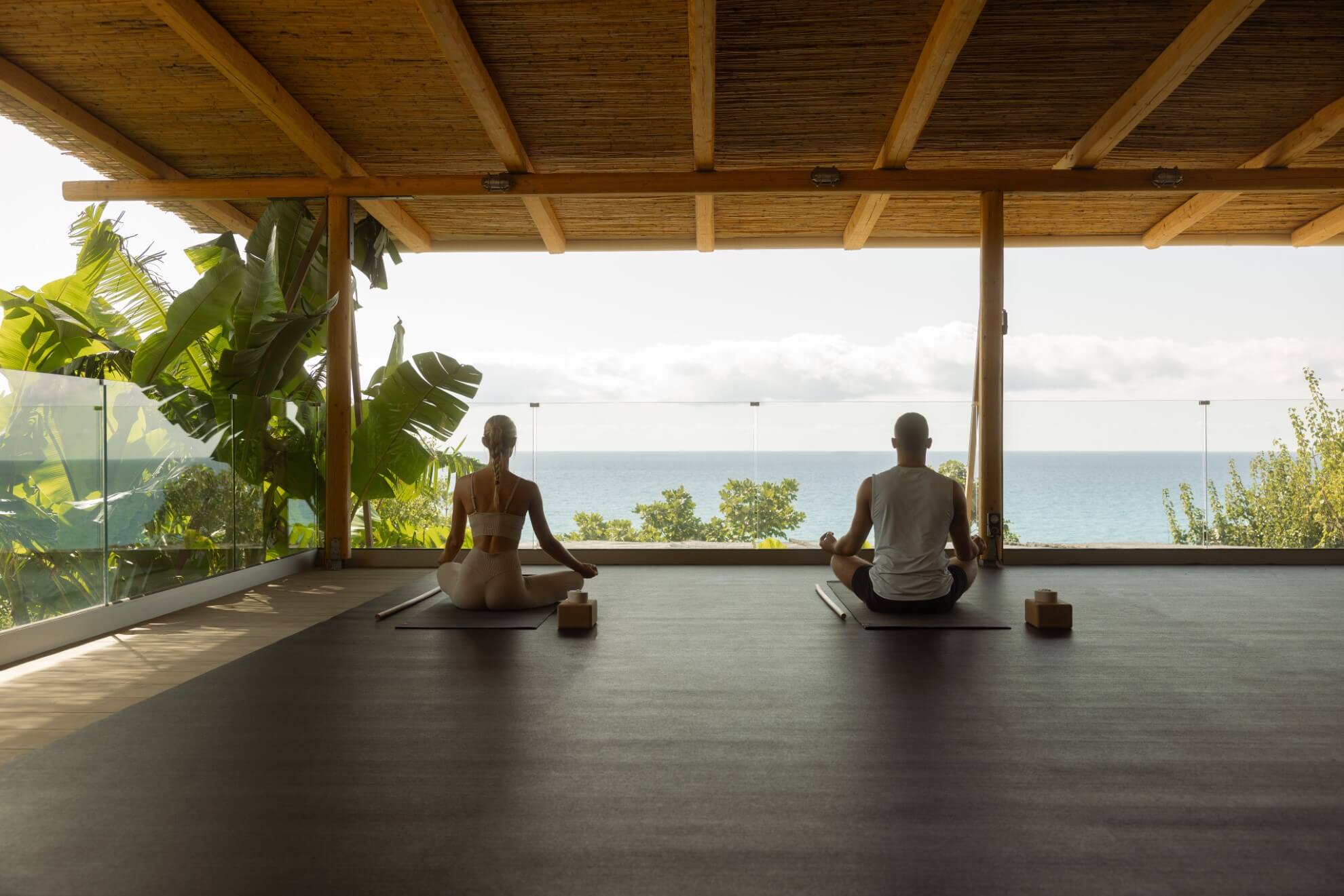 a couple doing yoga with sea view